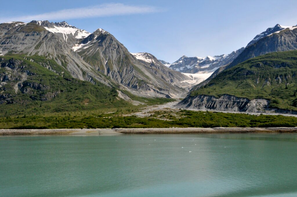 Glacier flowing into a green valley in Glacier Bay National Park, Alaska