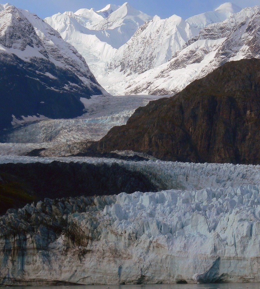 Margerie Glacier winding down through snow-capped mountains in Glacier Bay, Alaska.