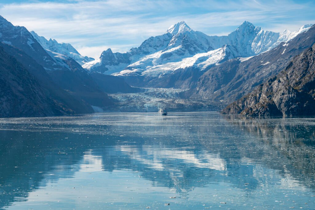 Cruise ship dwarfed by Johns Hopkins Glacier in Glacier Bay, Alaska — choosing the best Alaska cruise line