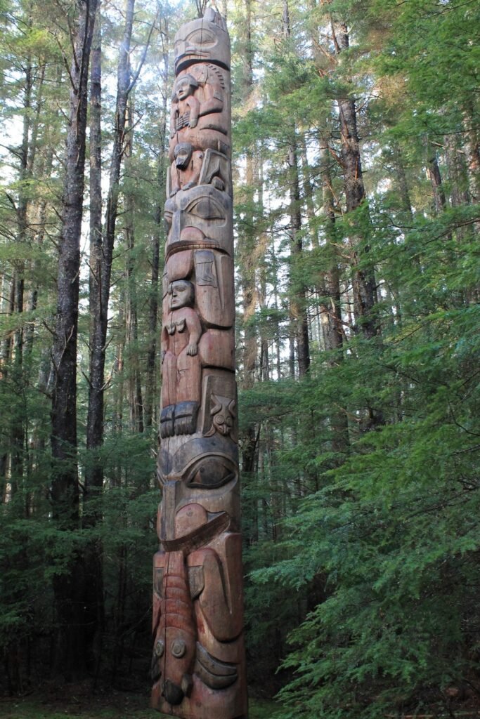 A carved totem pole standing in the coastal rainforest at Sitka National Historical Park, one of the lesser known Alaska cruise ports.